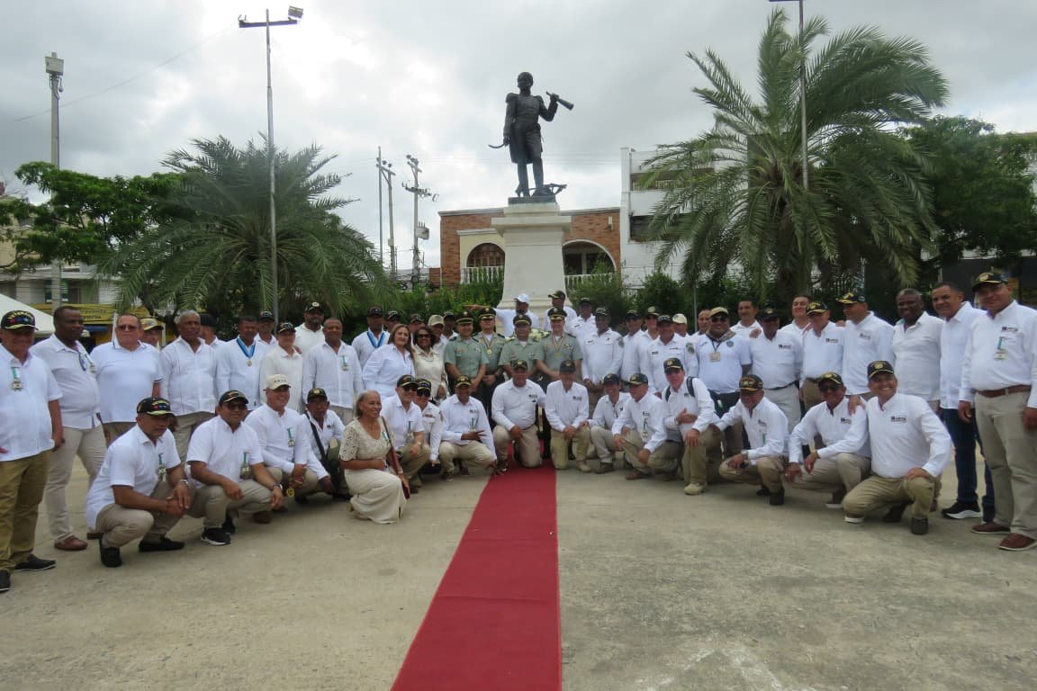 Foto de grupo de los asistentes a la ceremonia del Día del Veterano frente al monumento en Riohacha